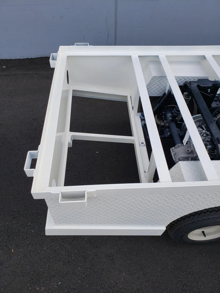 Close-up of a white metal frame structure with diamond plate paneling designed as STAKEBED POCKETS FOR 6 FT FLATBED DECK CONVERSION, custom fabrication for golf carts.