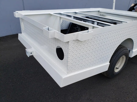 White metal stakebed pockets designed for custom fabrication on a 6 ft flatbed deck conversion, featuring diamond plate texture and utility box elements for golf carts.