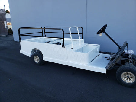 A white utility golf cart with DROP RAILS 44″ X 72″ X 18″ FLATBED SIDE RAILS FOR 6 FT FLATBED CONVERSION installed, featuring custom fabrication for golf carts.