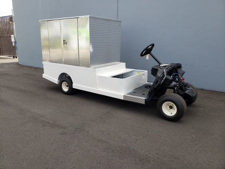 FMB-44X72X48-S-D3W0 FLATBED ALUMINUM SMOOTH MULTI-PURPOSE BOX 44″ WIDE X 72″ LONG X 48″ TALL WITH LOCKING DOORS mounted on a custom fabrication for golf carts, featuring flatbed utility cargo storage.