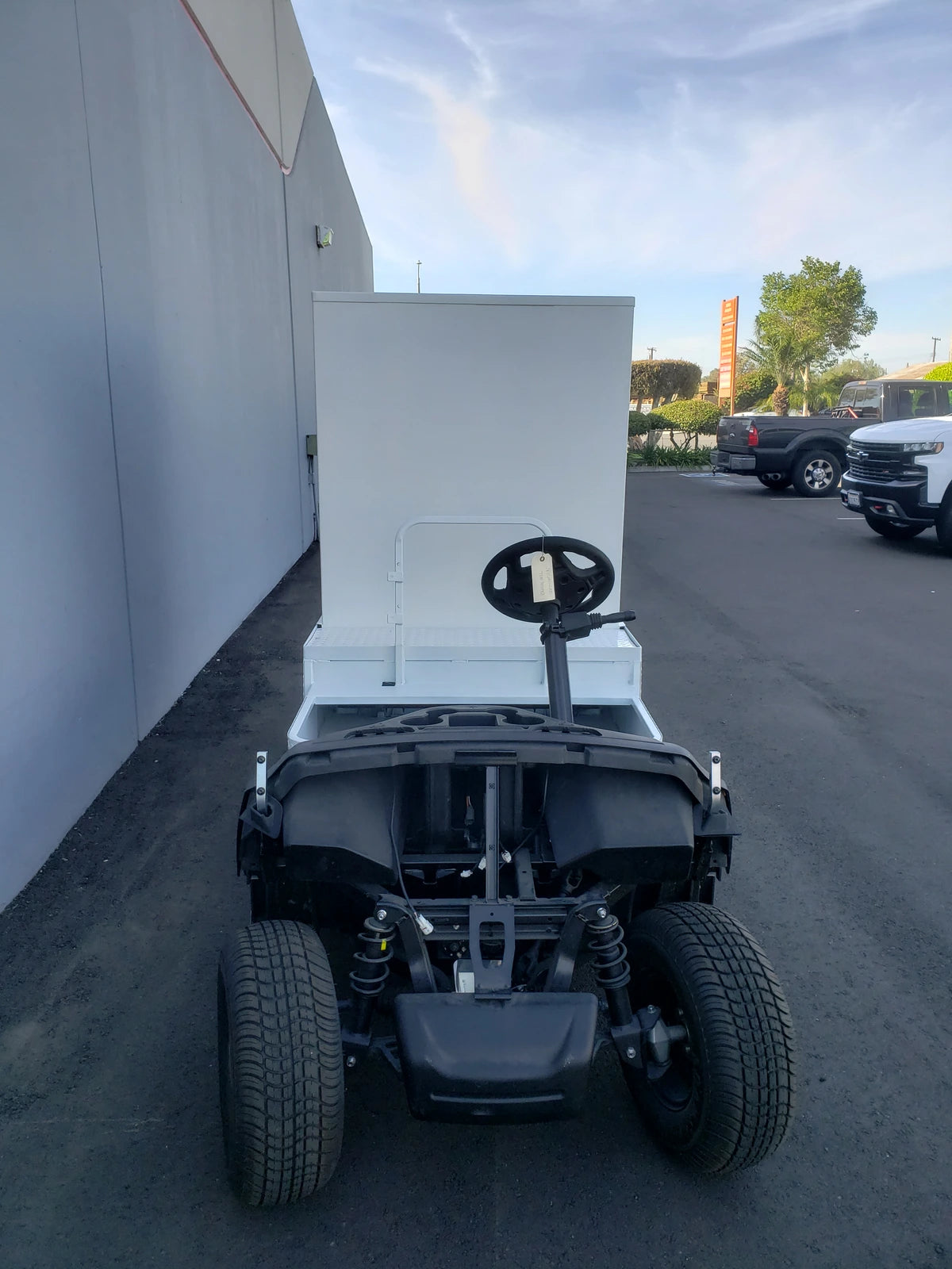 A golf cart fitted with a custom fabricated FMB-44X72X48-D-D2W0 FLATBED ALUMINUM DIAMOND PLATE MULTI-PURPOSE BOX, designed for versatile cargo and utility use.