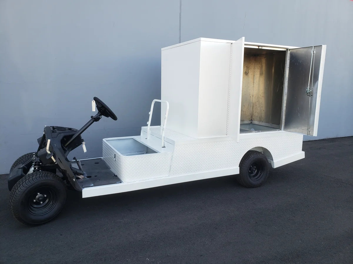 FMB-44X72X48-S-D2W0 FLATBED ALUMINUM SMOOTH MULTI-PURPOSE BOX mounted on a custom fabrication golf cart with an open rear compartment and white smooth aluminum flatbed.