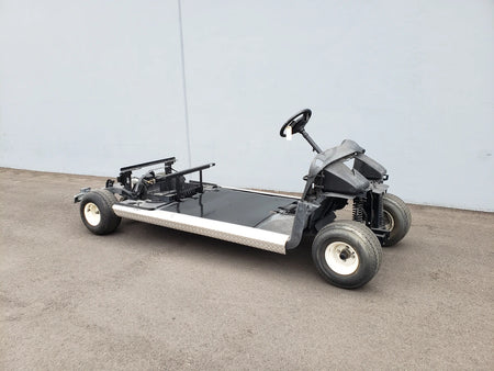 Bare golf cart frame with steering wheel and wheels, showcasing custom fabrication for golf carts in the EZGO-RXV-PS6-4F+2B EZGO RXV 6 PASSENGER CONVERSION.