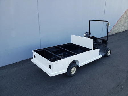 EZGO-RXV-ST-FLAT-72 EZ GO RXV FLATBED RETROFIT CONVERSION golf cart featuring custom fabrication with a white flatbed cargo area for utility and specialty golf cart beds.