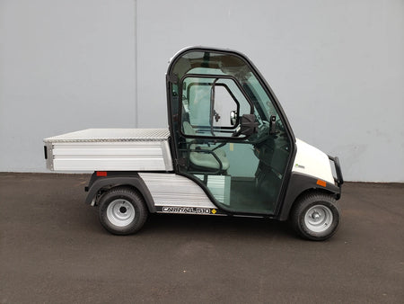 White utility cart with enclosed cabin and flatbed cargo area, featuring the CC-510-UTILITYBOX-LID CLUB CAR 510 UTILITY BOX SOLID LOCKING LID RETROFIT for secure storage and transport.