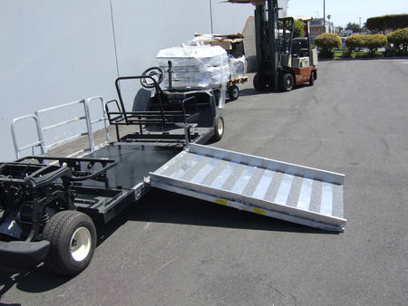 Utility trailer with a ramp attached on a paved surface.