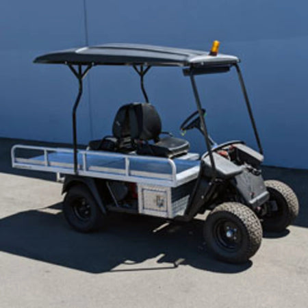 Black golf cart with a custom flatbed conversion, featuring side rails and a roof, designed as EZGO-EMT-84X24 EMT GOLF CART BED CONVERSION FOR EZ GO TXT GOLF CART for specialty utility and cargo use.