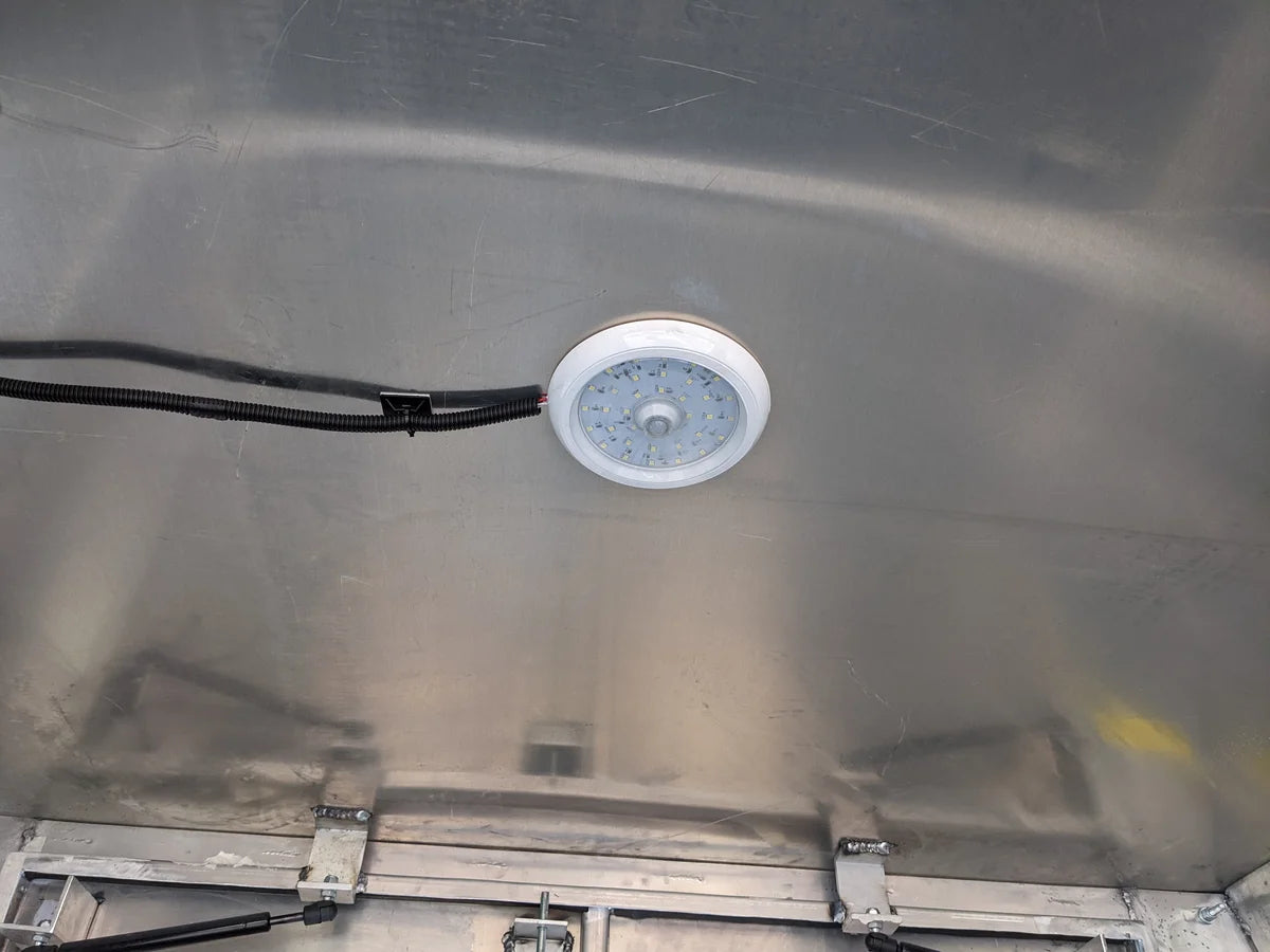 Interior view of a metal flatbed box featuring the FMB-DOME LIGHT for Flatbed Multipurpose Box installed on the ceiling, showcasing custom fabrication for golf carts.