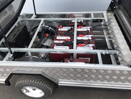 TBA-48X46X19 ALUMINUM TILT BED FOR GOLF CART showing custom fabrication with metal frame and multiple batteries installed for utility and cargo use on a golf cart.