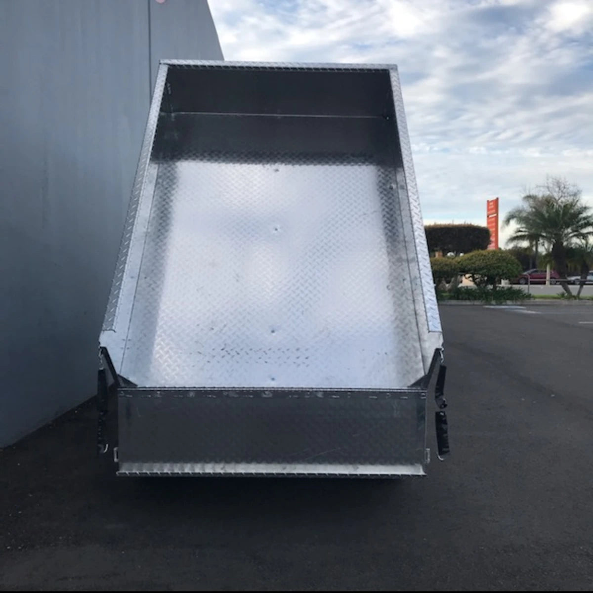 TBA-48X46X19 ALUMINUM TILT BED FOR GOLF CART shown tilted open, made from durable aluminum with a diamond plate pattern, designed for custom fabrication and specialty golf cart cargo use.