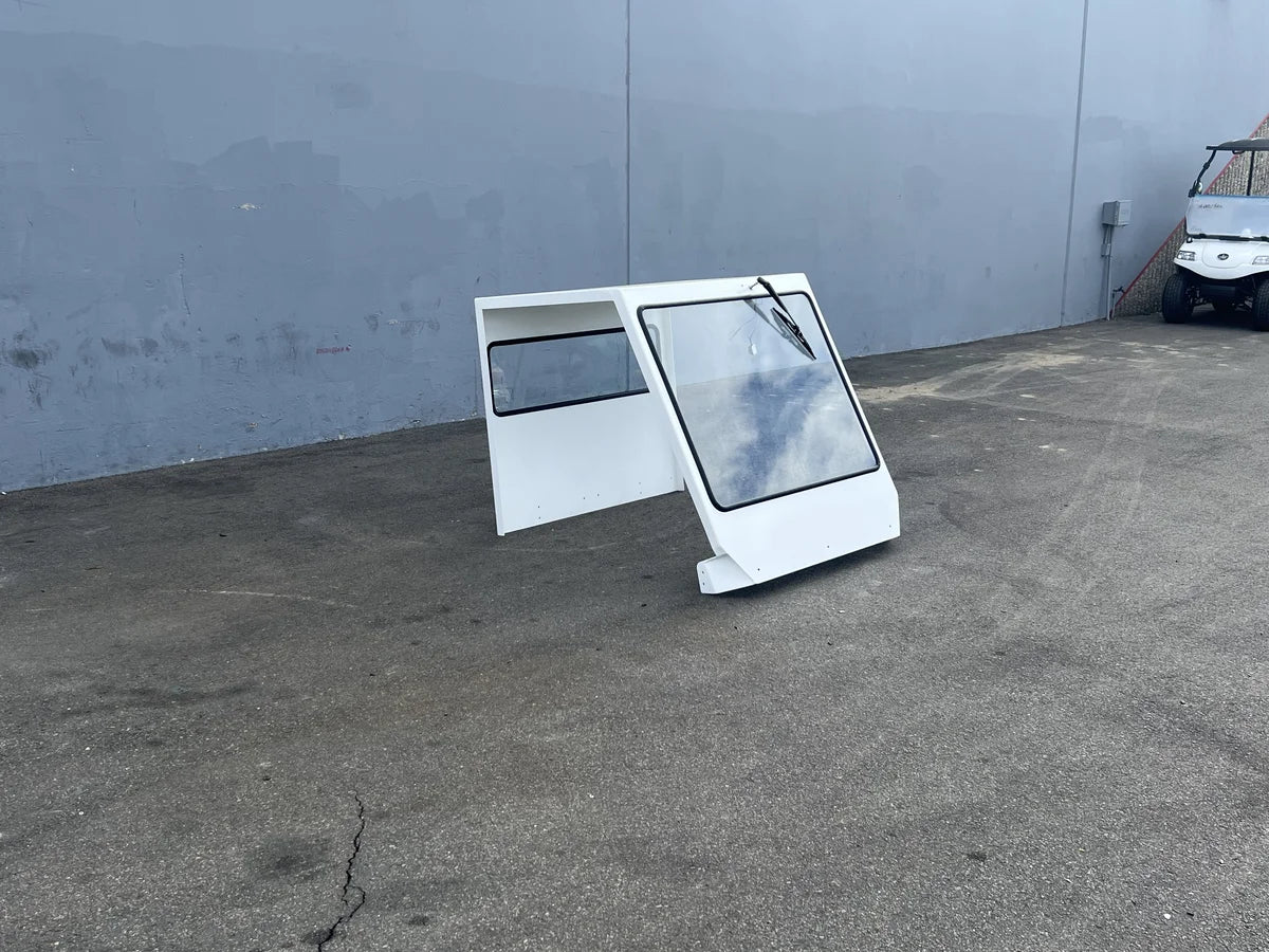 SCE-TDBIG-CAB-ND CAB ENCLOSURE FOR TAYLOR DUNN BIGFOOT, NO DOORS, white custom fabrication designed for golf carts, including a large windshield and side panels.