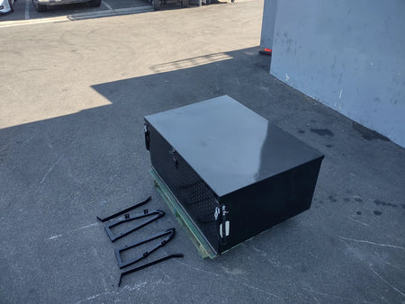 YAM-DRIVE2-CARGO31 YAMAHA DRIVE 2 LOCKING CARGO BOX in black metal with custom fabrication for golf carts, shown with mounting brackets on a pavement surface.