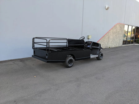 CUSH-800-ST-FLAT-72 CUSHMAN HAULER 800 CART STRETCHED INTO 6′ FLATBED with custom fabrication for golf carts featuring a spacious black flatbed cargo area and sturdy guardrails for utility and cargo transport.