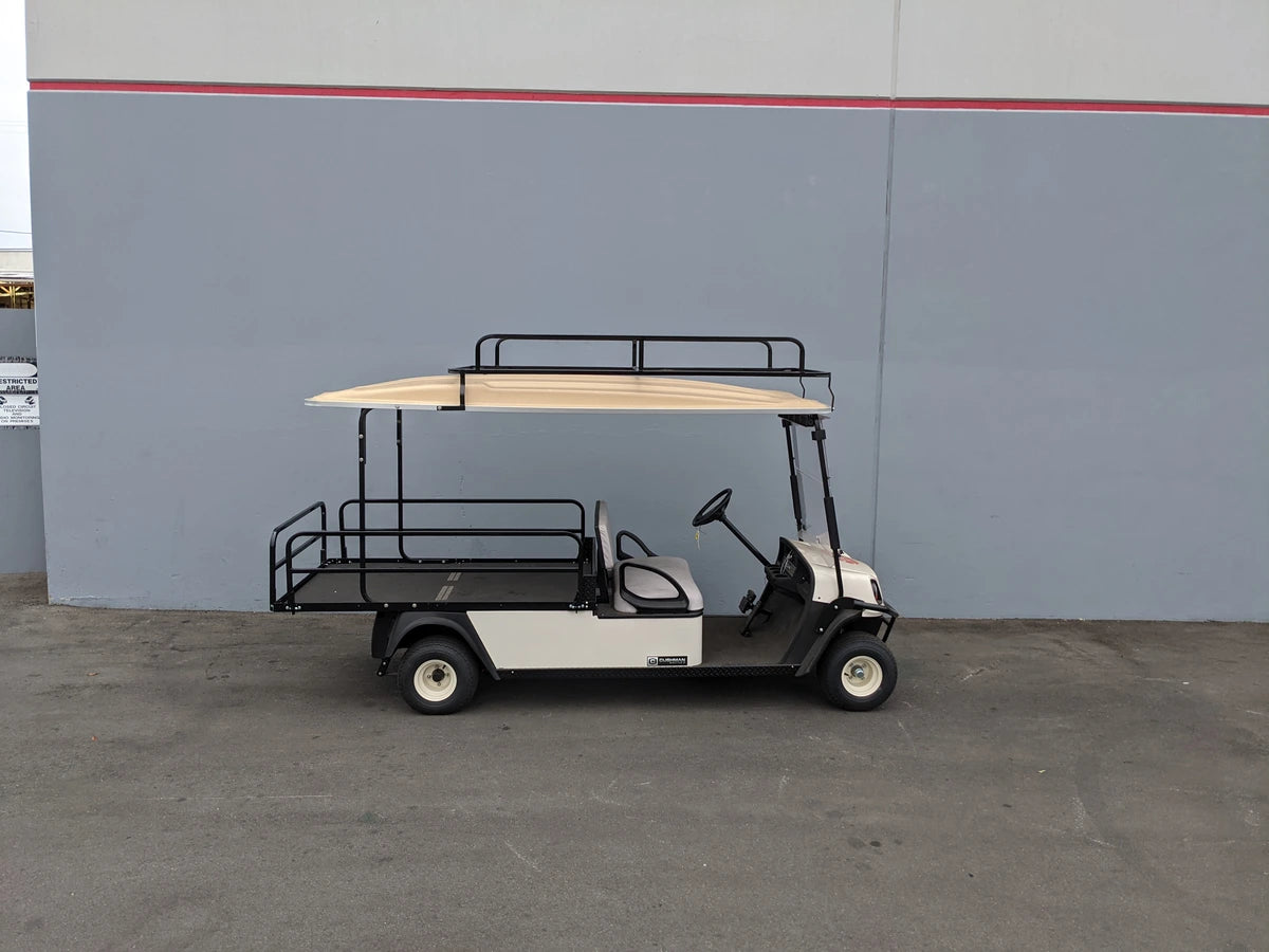 White golf cart equipped with CUSH-SHUTTLE2-84LR CUSHMAN SHUTTLE 2 LADDER RACK custom fabricated for golf carts, featuring a black metal ladder rack and cargo area.