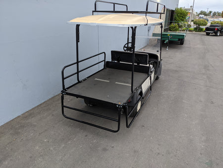 CUSH-SHUTTLE2-DROP-RAILS CUSHMAN SHUTTLE 2 DROP RAIL SET installed on golf cart with flatbed cargo area, custom fabrication for golf carts, featuring durable black metal rails and canopy support.