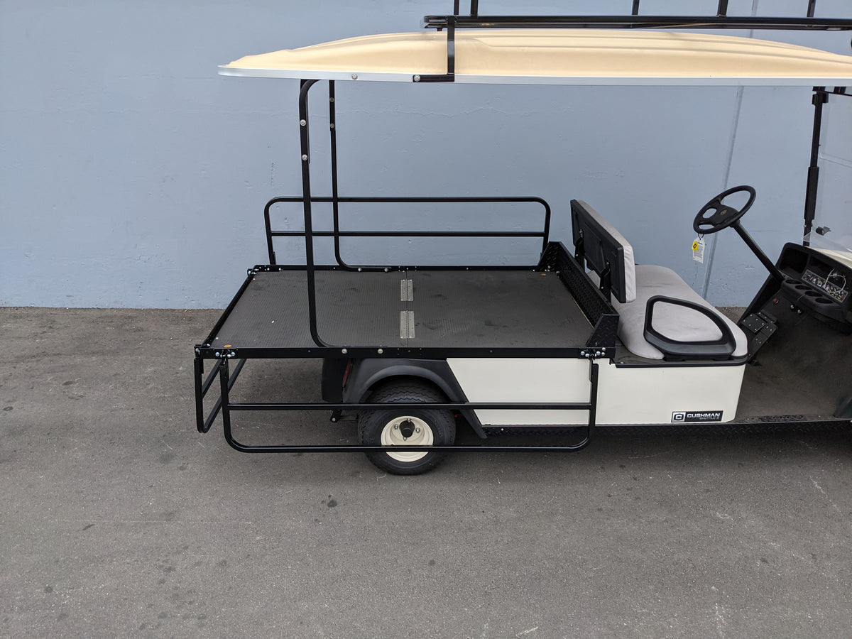 Black metal custom fabrication drop rails installed on the flatbed of a golf cart, designed for utility and cargo transport, shown with the CUSH-SHUTTLE2-DROP-RAILS CUSHMAN SHUTTLE 2 DROP RAIL SET.