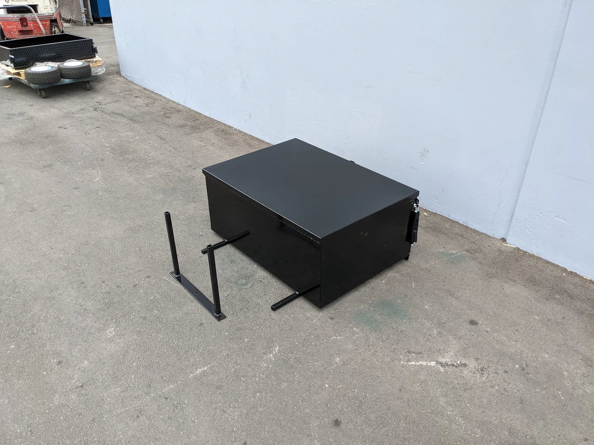 Black heavy-duty locking cargo box designed as custom fabrication for golf carts, shown with mounting brackets on concrete near a white wall, EZGO-RXV-CARGO31 EZ GO RXV HEAVY-DUTY LOCKING CARGO BOX