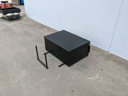 Black heavy-duty locking cargo box designed as custom fabrication for golf carts, shown with mounting brackets on concrete near a white wall, EZGO-RXV-CARGO31 EZ GO RXV HEAVY-DUTY LOCKING CARGO BOX