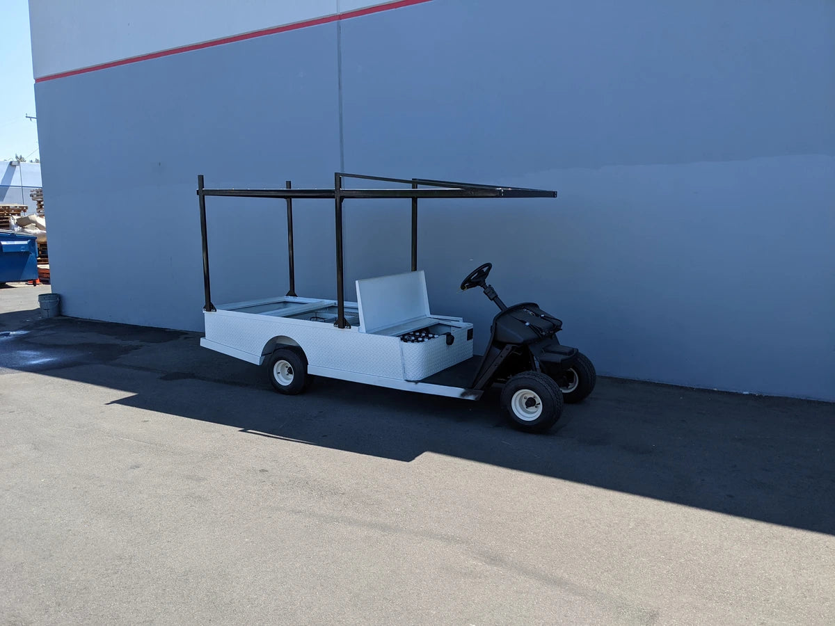 Golf cart equipped with FB-45X120-TLR FLATBED TOP LADDER RACK, 45″ X 120″ WITH REMOVABLE REAR CROSS BAR, custom fabricated for golf carts for transporting cargo and ladders.