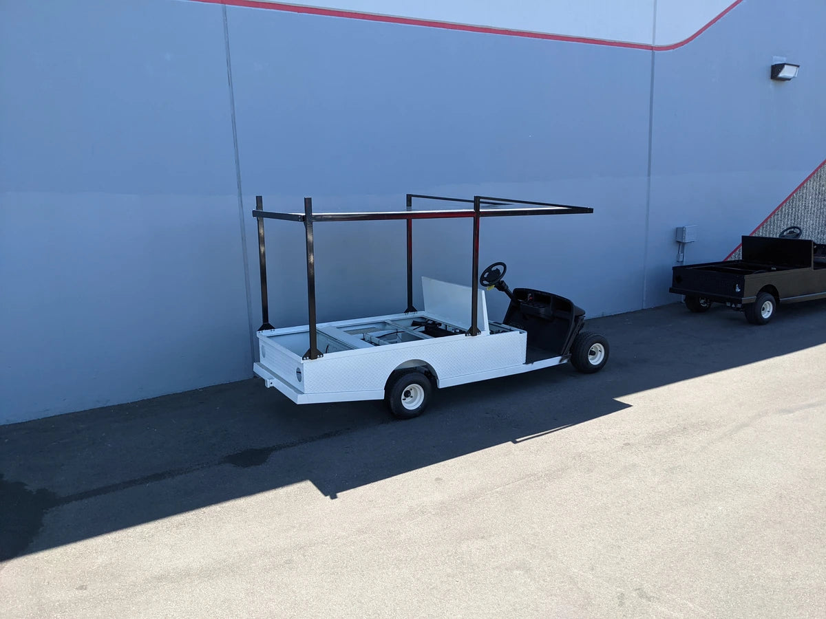 White golf cart with FB-45X120-TLR FLATBED TOP LADDER RACK, 45″ X 120″ WITH REMOVABLE REAR CROSS BAR installed, custom fabricated for golf carts, ideal for hauling ladders and cargo.
