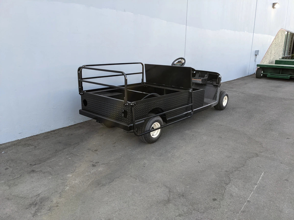 Black utility golf cart with flatbed cargo area designed for heavy-duty use, featuring custom fabrication for golf carts, identified as EZGO-RXV-ST-FLAT-60 EZ GO RXV FLATBED RETROFIT CONVERSION.