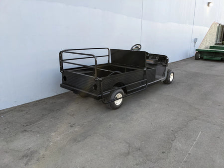 Black utility golf cart with flatbed cargo area designed for heavy-duty use, featuring custom fabrication for golf carts, identified as EZGO-RXV-ST-FLAT-60 EZ GO RXV FLATBED RETROFIT CONVERSION.
