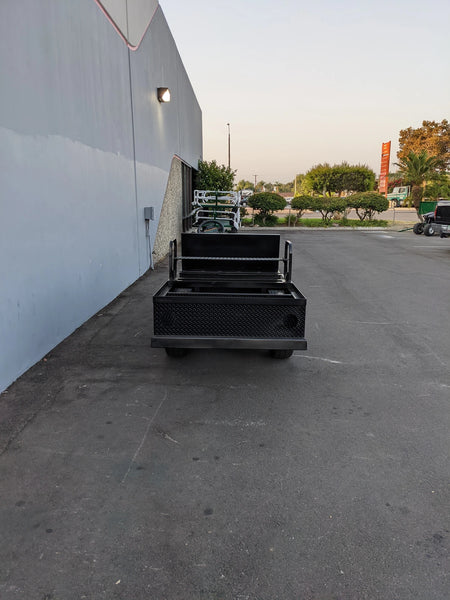 EZGO-RXV-ST-FLAT-CONV-72 EZ GO RXV FLATBED RETROFIT WITH CONVERTIBLE SEAT parked outside near a building, showcasing custom fabrication for golf carts with flatbed and convertible seating features.
