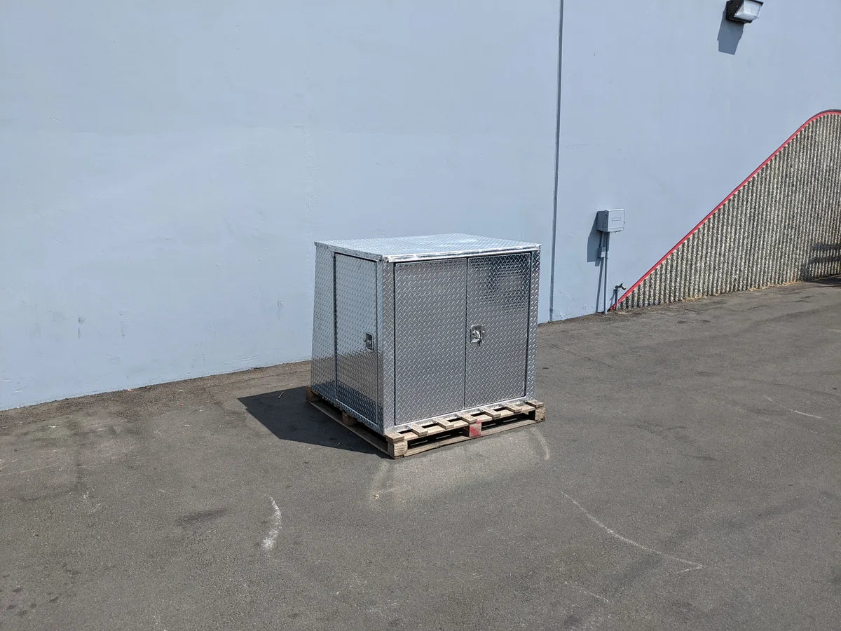 YAM-UMAX-CARGO42X48X42-4D Locking Cargo Box with Doors on Three Sides made of metal, placed on a wooden pallet outdoors, designed for custom fabrication for golf carts.