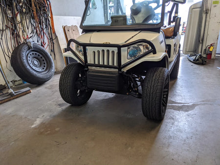 Front view of a white golf cart fitted with the TOM-EMERGE-E2-BG TOMBERLIN EMERGE E2 BRUSH GUARD, custom fabricated for golf carts, protecting the front grill and headlights.