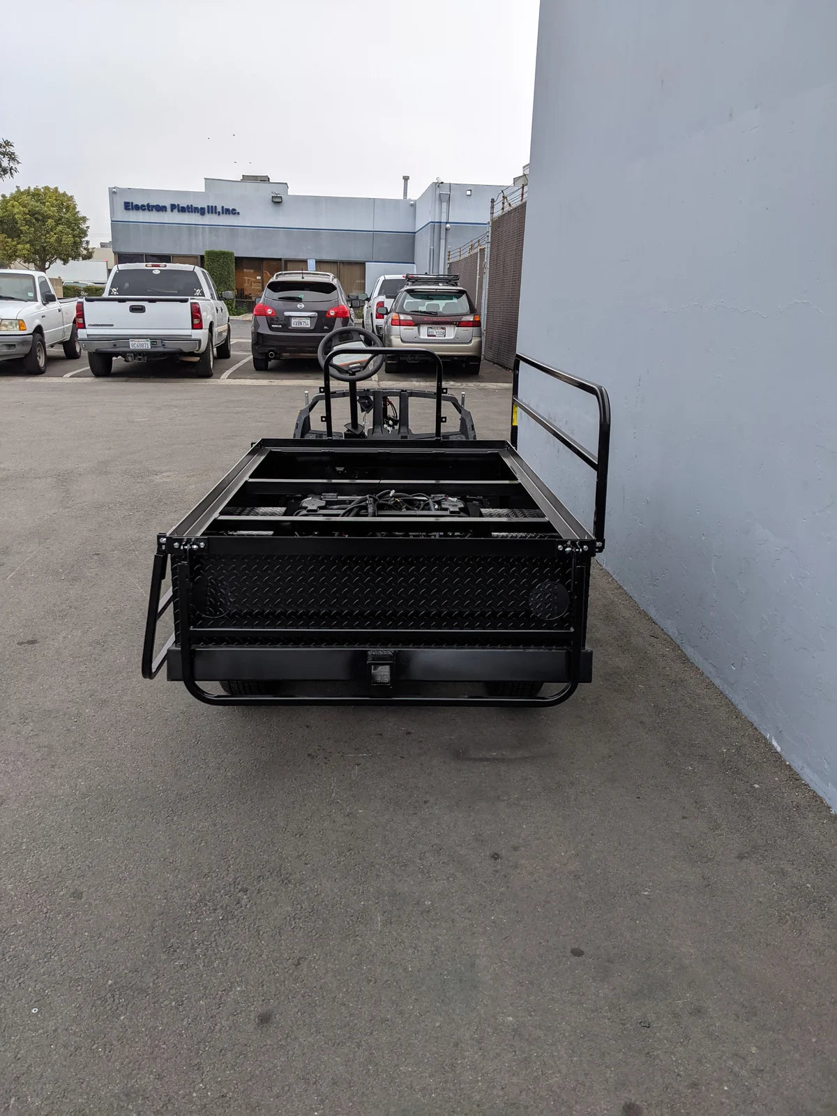 A black custom-fabricated flatbed conversion for golf carts, showing the rear storage and framework of the YAM-DRIVE2-ST-FLAT-72 YAMAHA DRIVE 2 6FT FLATBED CONVERSION.