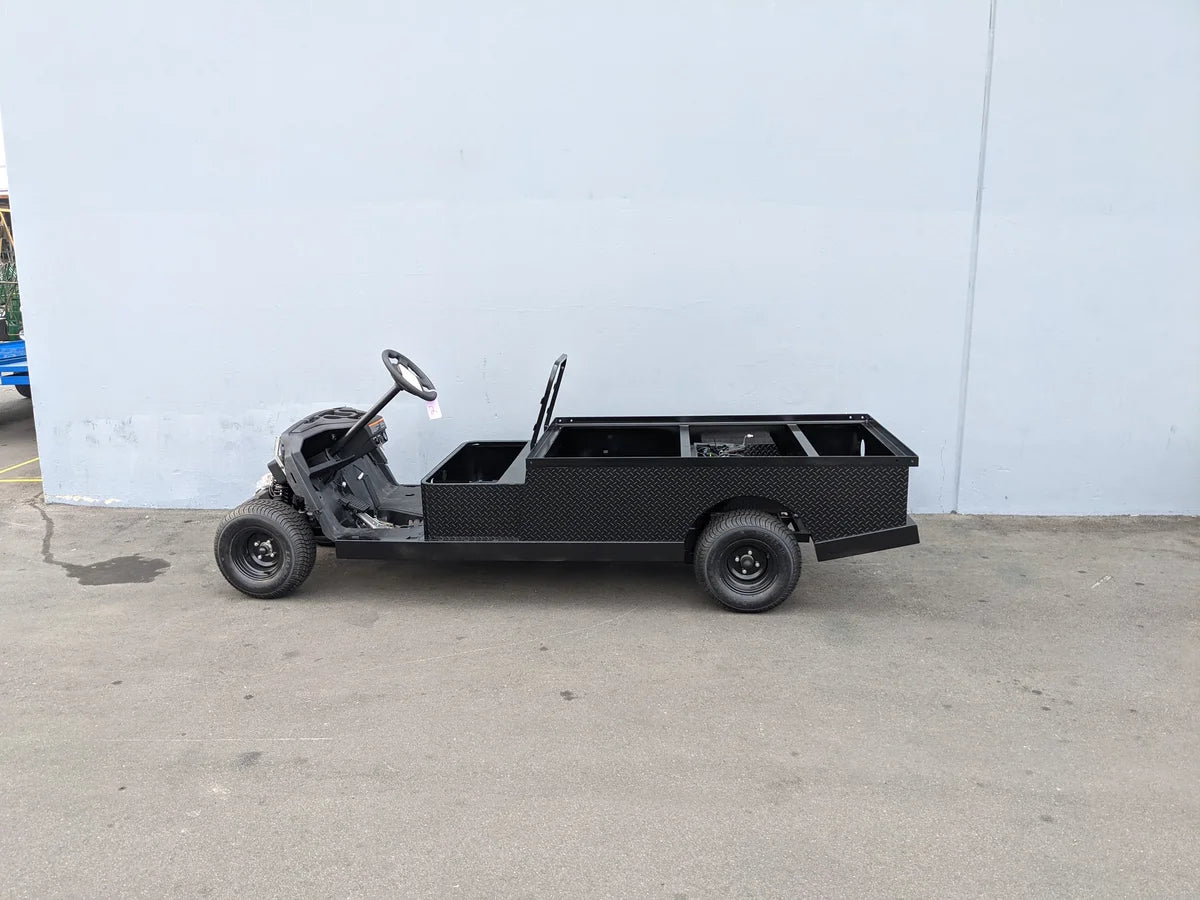 Side view of a partially assembled custom flatbed golf cart conversion with open cargo area and black diamond plate surface, designed as YAM-DRIVE2-ST-FLAT-72 YAMAHA DRIVE 2 6FT FLATBED CONVERSION for unique golf cart utility needs.