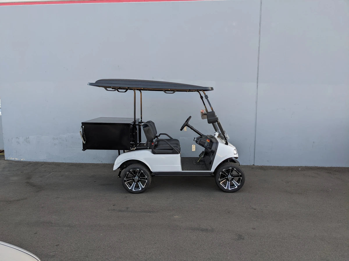 White golf cart equipped with EVO-CLASSIC-CARGO31 EVOLUTION CLASSIC LOCKING CARGO BOX mounted at the back, designed as a custom fabrication for golf carts, useful for cargo and utility purposes.