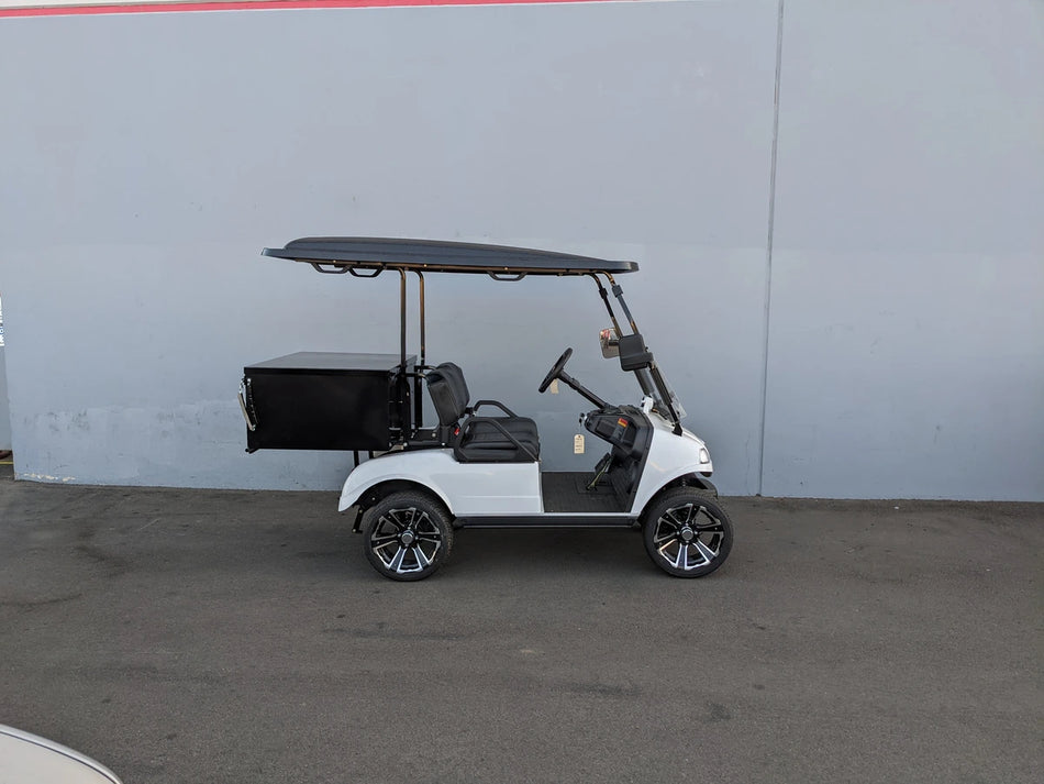 White golf cart equipped with EVO-CLASSIC-CARGO31 EVOLUTION CLASSIC LOCKING CARGO BOX mounted at the back, designed as a custom fabrication for golf carts, useful for cargo and utility purposes.