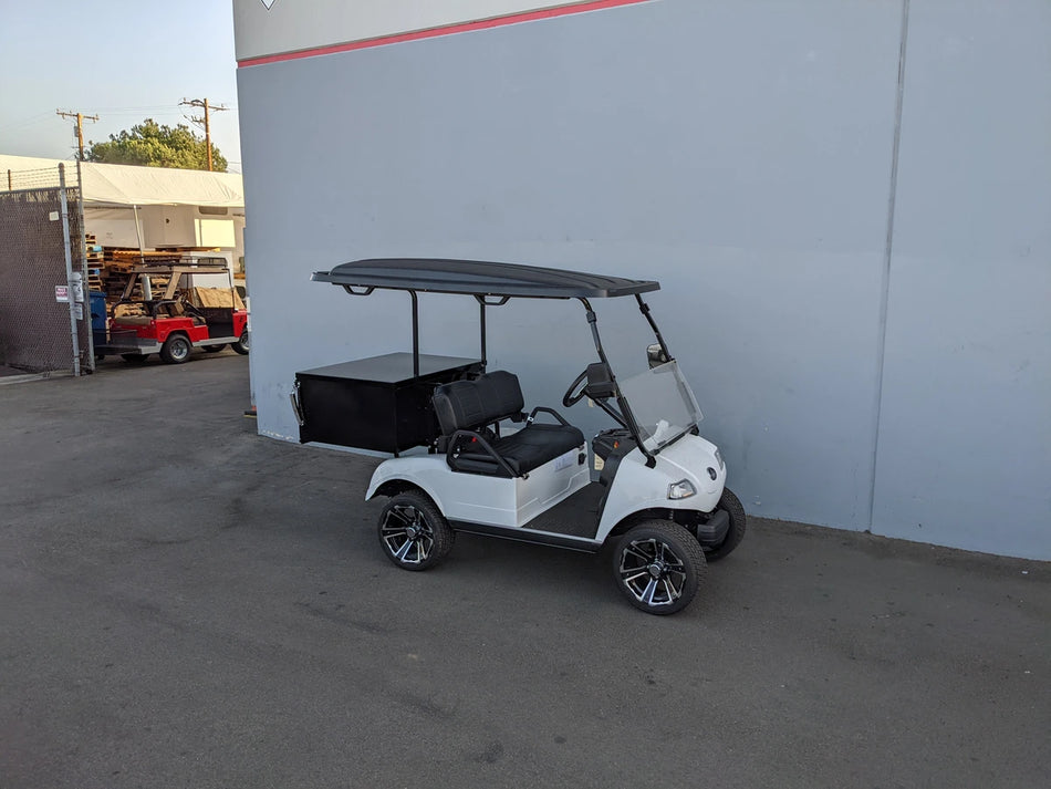 White golf cart equipped with black EVO-CLASSIC-CARGO31 EVOLUTION CLASSIC LOCKING CARGO BOX on custom-fabricated flatbed for utility and cargo transport.