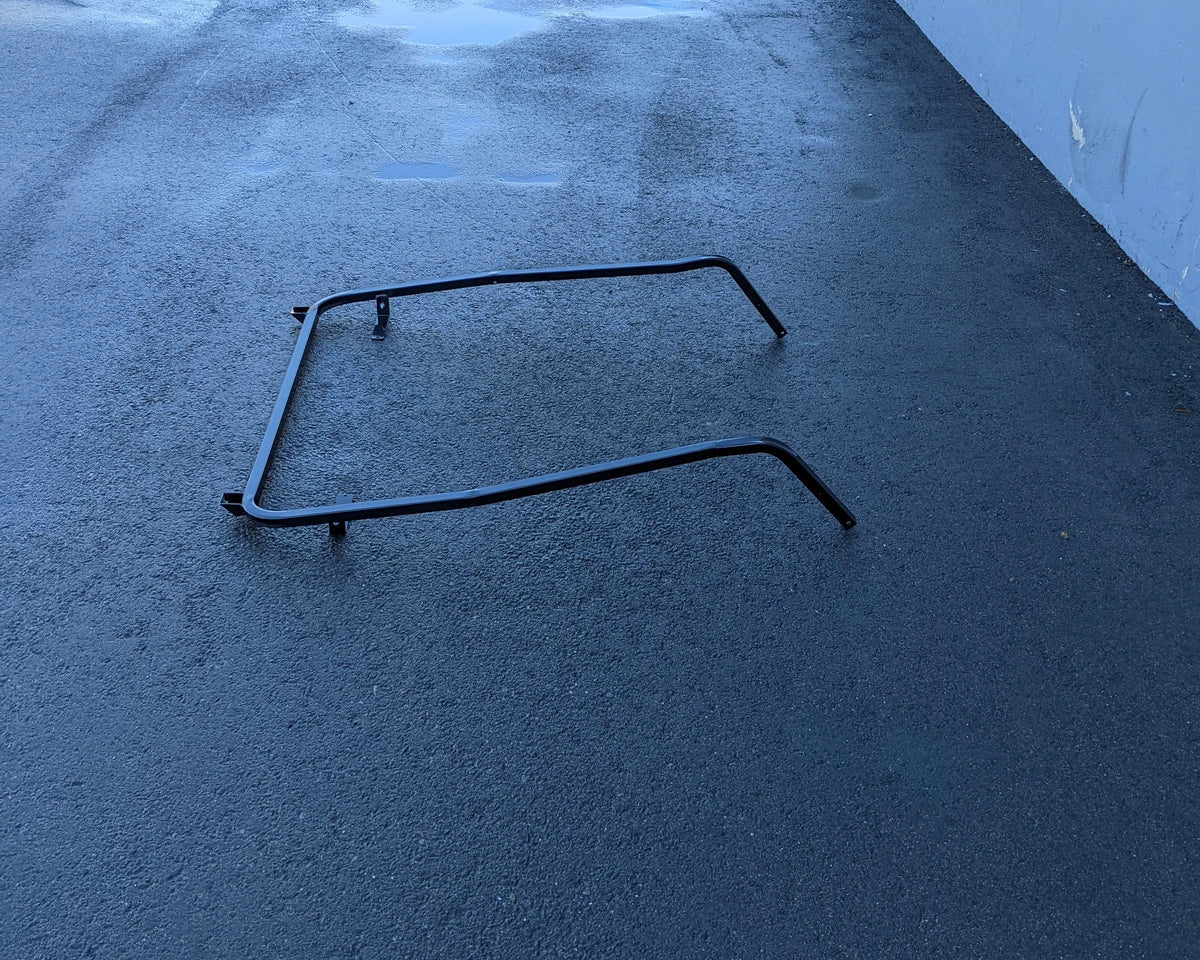 CC-DS08+-FTS CLUB CAR DS 2008 AND NEWER MODEL FRONT TOP SUPPORT metal frame part shown on black asphalt surface against a blue wall background.