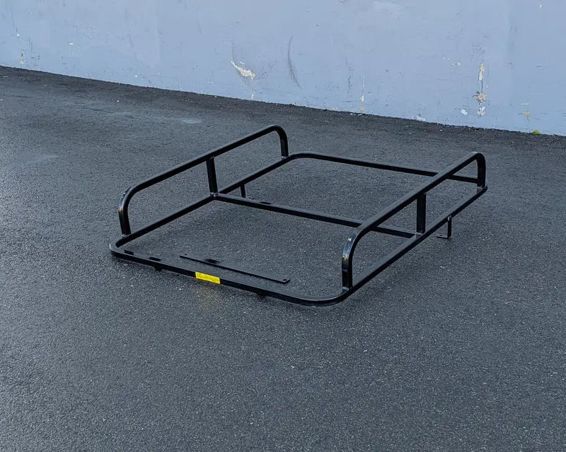 Black metal cargo rack on asphalt surface designed as the CC-PREC-50LRA CLUB CAR PRECEDENT ALUMINUM LADDER RACK, custom fabrication for golf carts.
