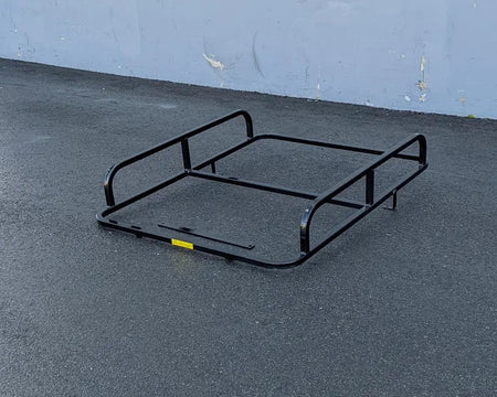 Black metal cargo rack on asphalt surface designed as the CC-PREC-50LRA CLUB CAR PRECEDENT ALUMINUM LADDER RACK, custom fabrication for golf carts.