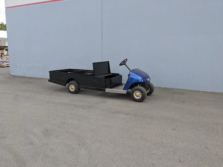 Golf cart with EZGO-TXT-ST-FLAT-72 6 FT FLATBED CONVERSION FOR EZ GO TXT featuring custom flatbed cargo area and utility box for specialized golf cart use.
