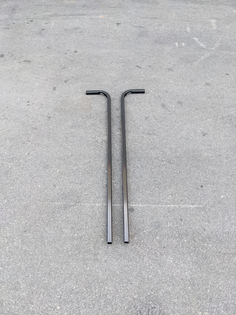 Two black metal bars with right-angle bends laid on a concrete surface, designed as CART-RTS GENERIC GOLF CART REAR TOP SUPPORT for golf cart accessories.