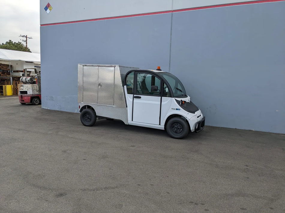 Small utility vehicle equipped with FMB-GEM-52X70X48-D-D2W0 Multi-Purpose Box for Flatbed, custom fabricated for golf carts, ideal for cargo and utility transport.