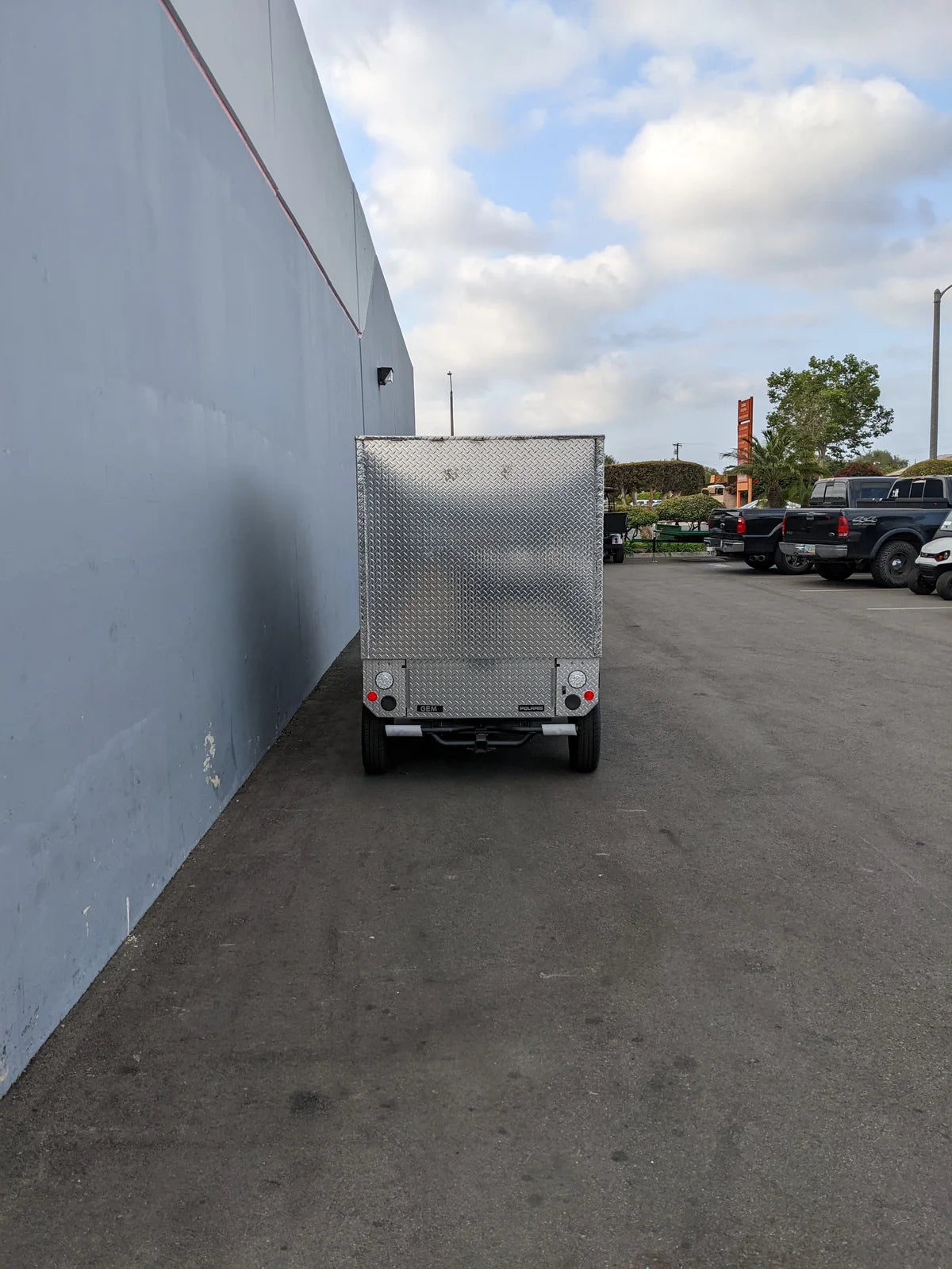 Rear view of the FMB-GEM-52X70X48-D-D2W0 Multi-Purpose Box for Flatbed mounted on a golf cart, showcasing custom fabrication designed for utility and cargo transport.