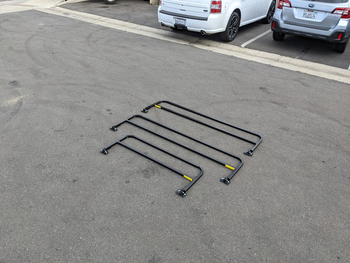 DROP RAILS 48″ X 66″ X 18″ FOR 5-1/2 FT FLATBED CONVERSION shown outdoors, four black metal rails designed as custom fabrication for golf carts, ideal for flatbed cargo and utility use.