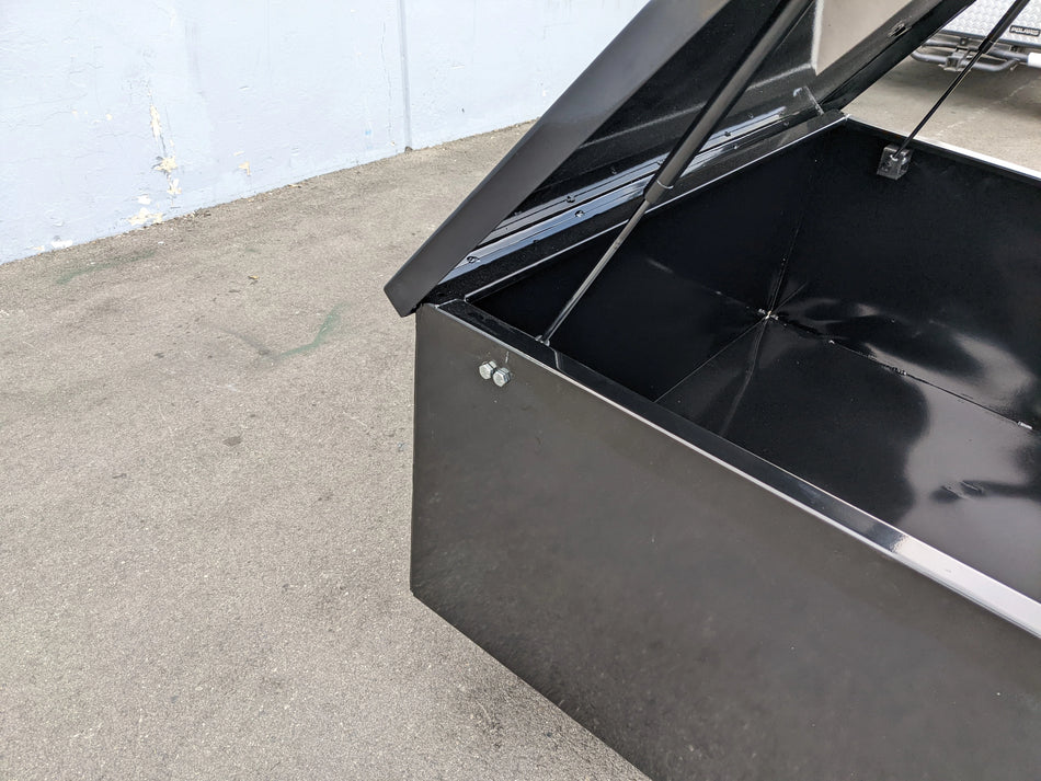 Black metal utility box lid held open by CARGO31-GAS-SPRING-RETROFIT GAS SPRING KIT FOR CART HAULERS CARGO BOX LID OPENING AND CLOSING, showing interior and mounting hardware.
