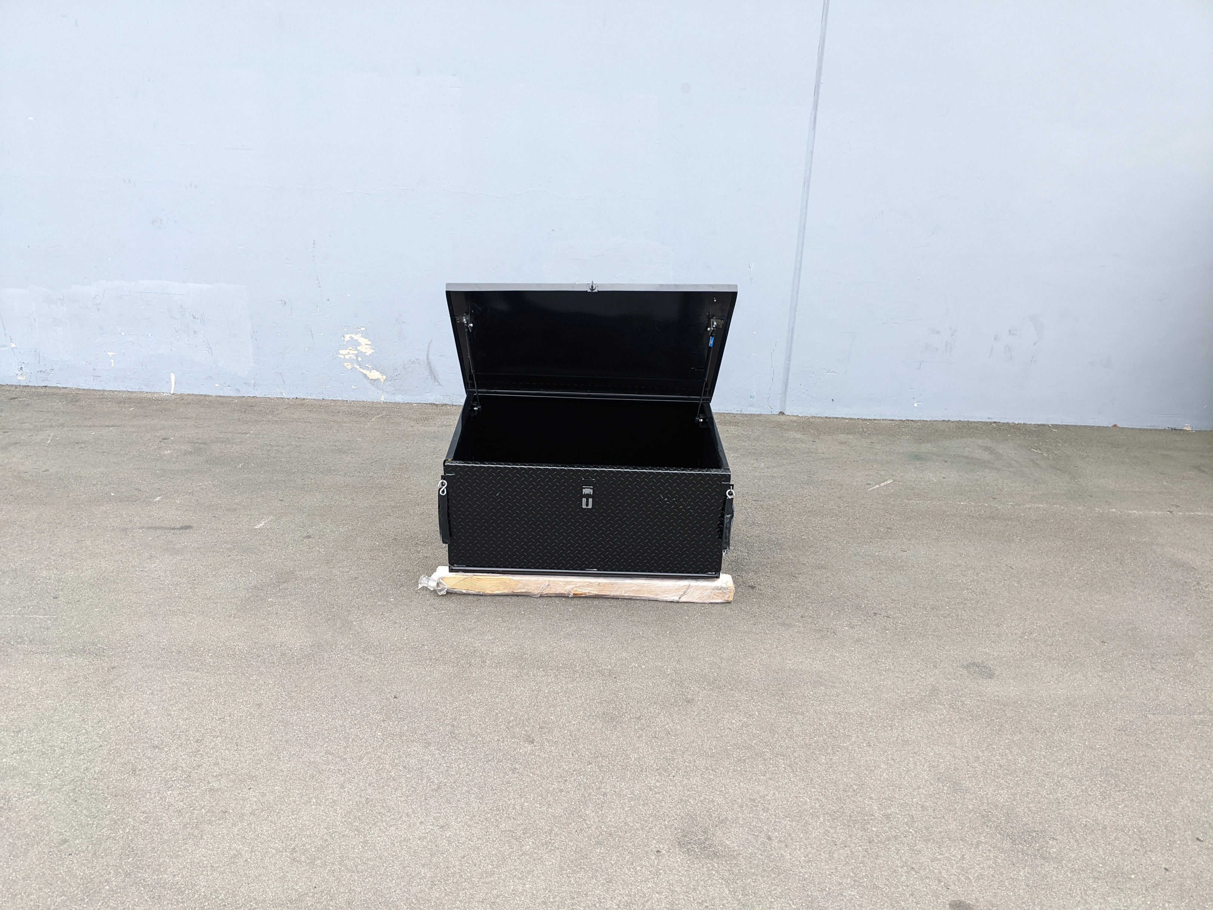 Black utility cargo box with open lid designed for secure storage, featured with CARGO31-GAS-SPRING-RETROFIT GAS SPRING KIT FOR CART HAULERS CARGO BOX LID OPENING AND CLOSING.