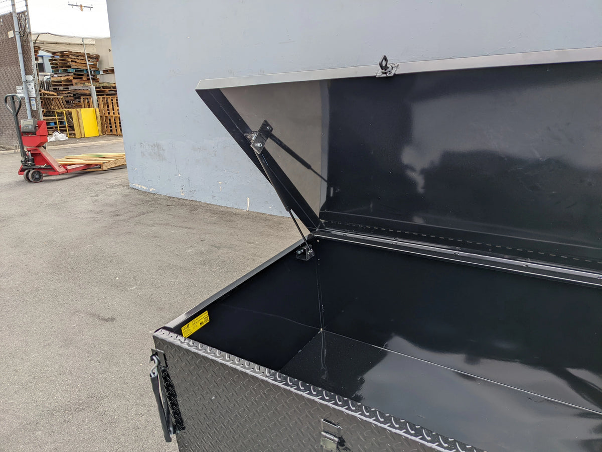 Open black utility cargo box with CARGO31-GAS-SPRING-RETROFIT GAS SPRING KIT FOR CART HAULERS CARGO BOX LID OPENING AND CLOSING shown supporting the lid for easy access.