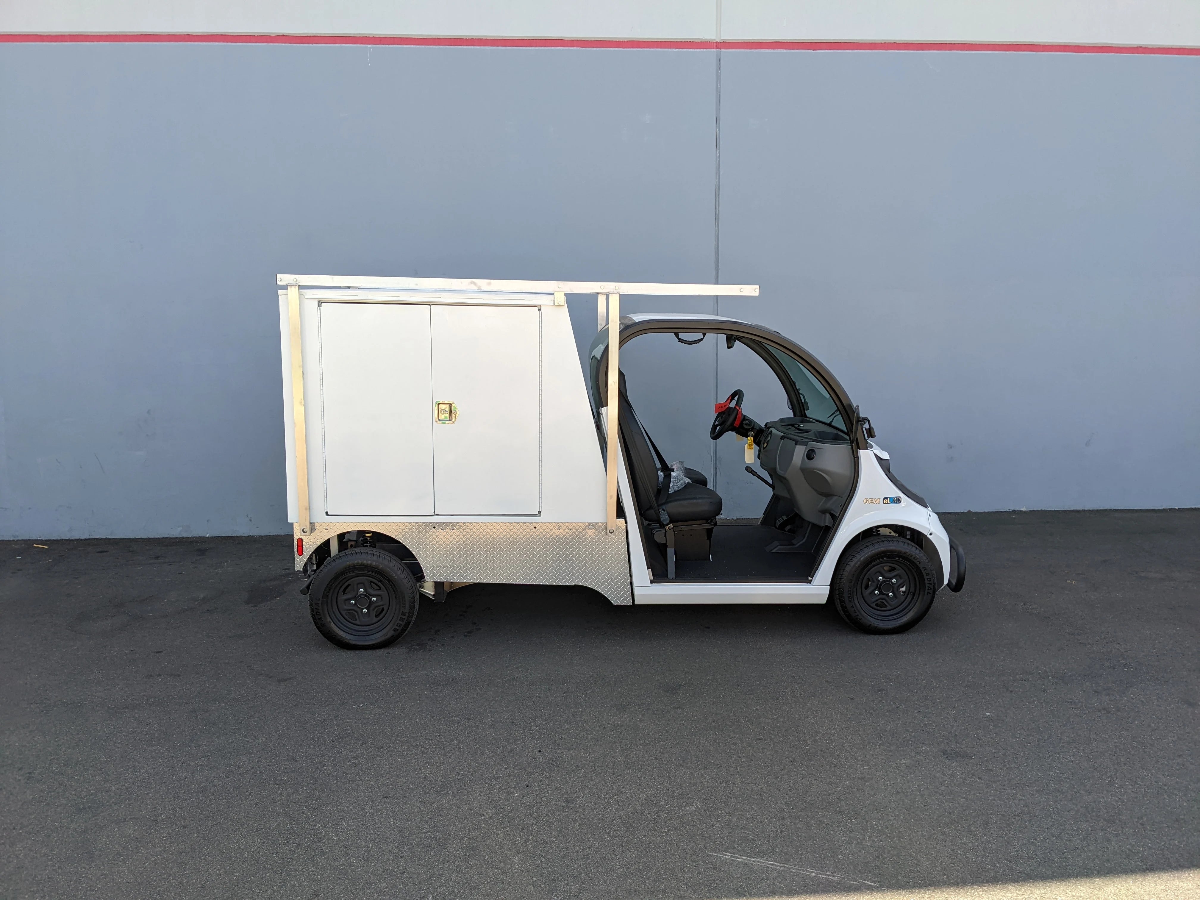 FMB-GEM-52X70X48-SL-D3W3 FLATBED ALUMINUM SMOOTH MULTI-PURPOSE LIGHT BOX FOR GEM ELXD 52″ WIDE X 70″ LONG X 48″ TALL WITH LOCKING DOORS installed on a custom fabrication golf cart for versatile cargo and utility transport.