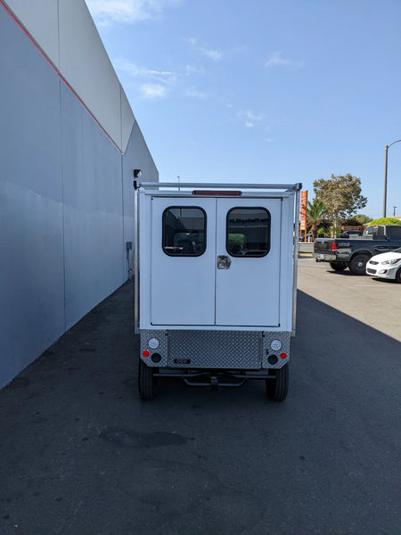 Rear view of a small utility vehicle equipped with the FMB-GEM-52X70X48-SL-D3W3 FLATBED ALUMINUM SMOOTH MULTI-PURPOSE LIGHT BOX FOR GEM ELXD 52″ WIDE X 70″ LONG X 48″ TALL WITH LOCKING DOORS, custom fabrication for golf carts.