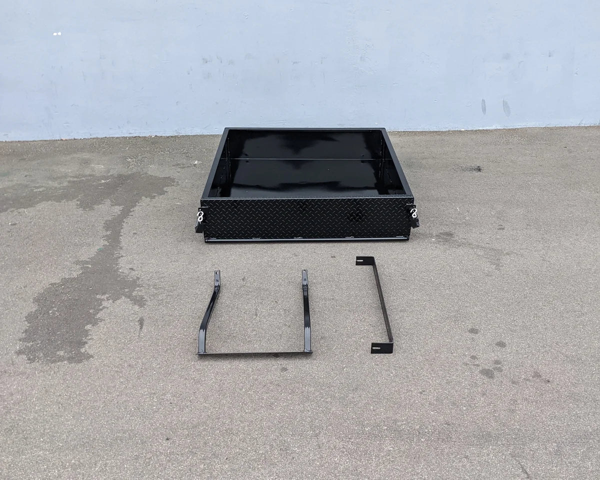 TOM-E2-UTIL48 TOMBERLIN EMERGE 2 Utility Box 48″ long shown with custom fabrication parts for golf carts, featuring a durable black metal cargo utility box and mounting brackets.