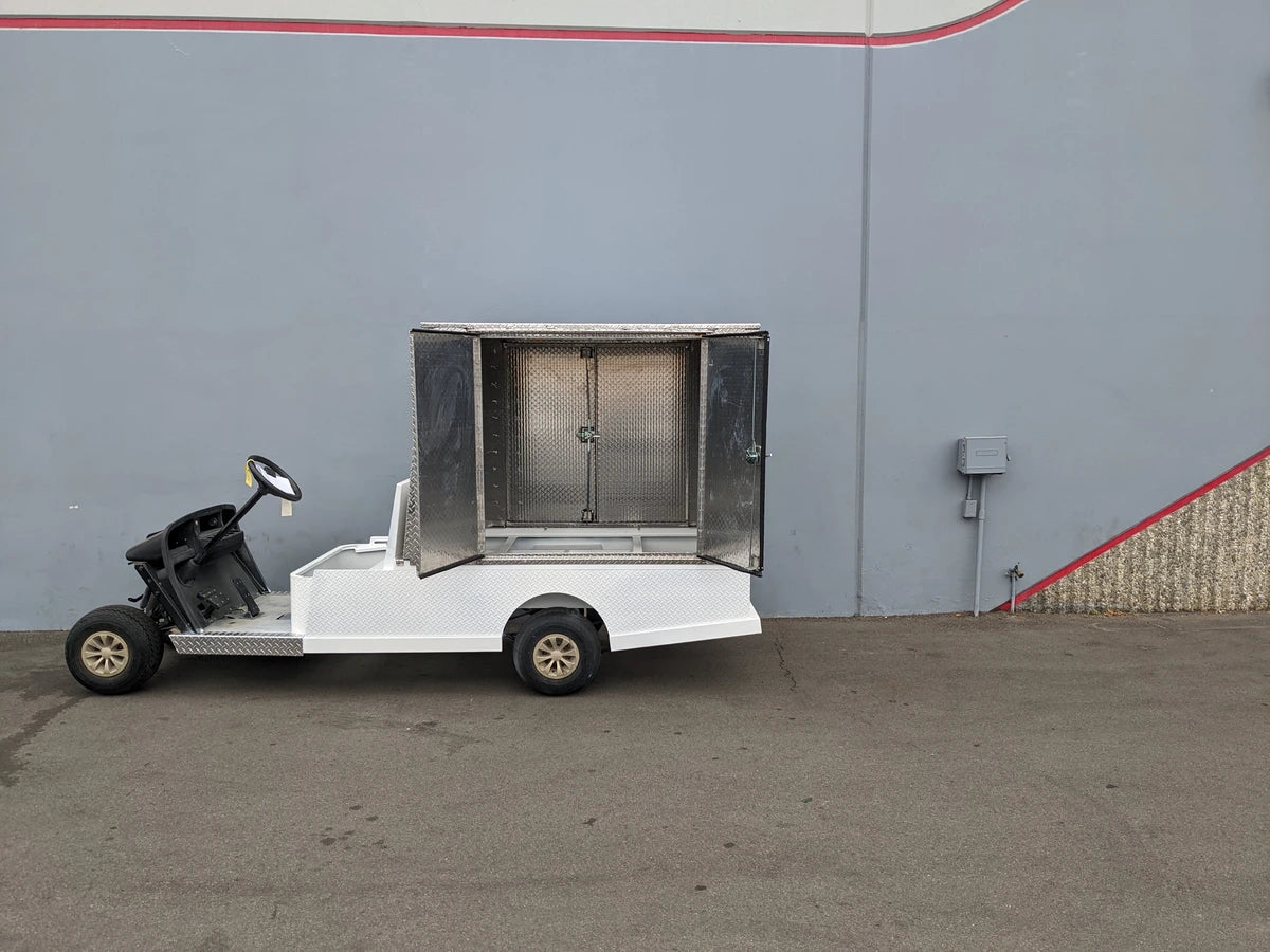 FMB-44X72X48-D-D2W0 FLATBED ALUMINUM DIAMOND PLATE MULTI-PURPOSE BOX mounted on a white golf cart frame, showcasing custom fabrication for golf carts with utility and cargo capabilities.