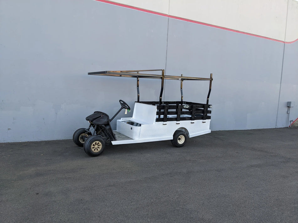 White custom golf cart with black FB-45X120-TLRI-INSIDE MOUNT 10 FT Top Mount Ladder Rack for Flatbed, designed for cargo and utility transport.